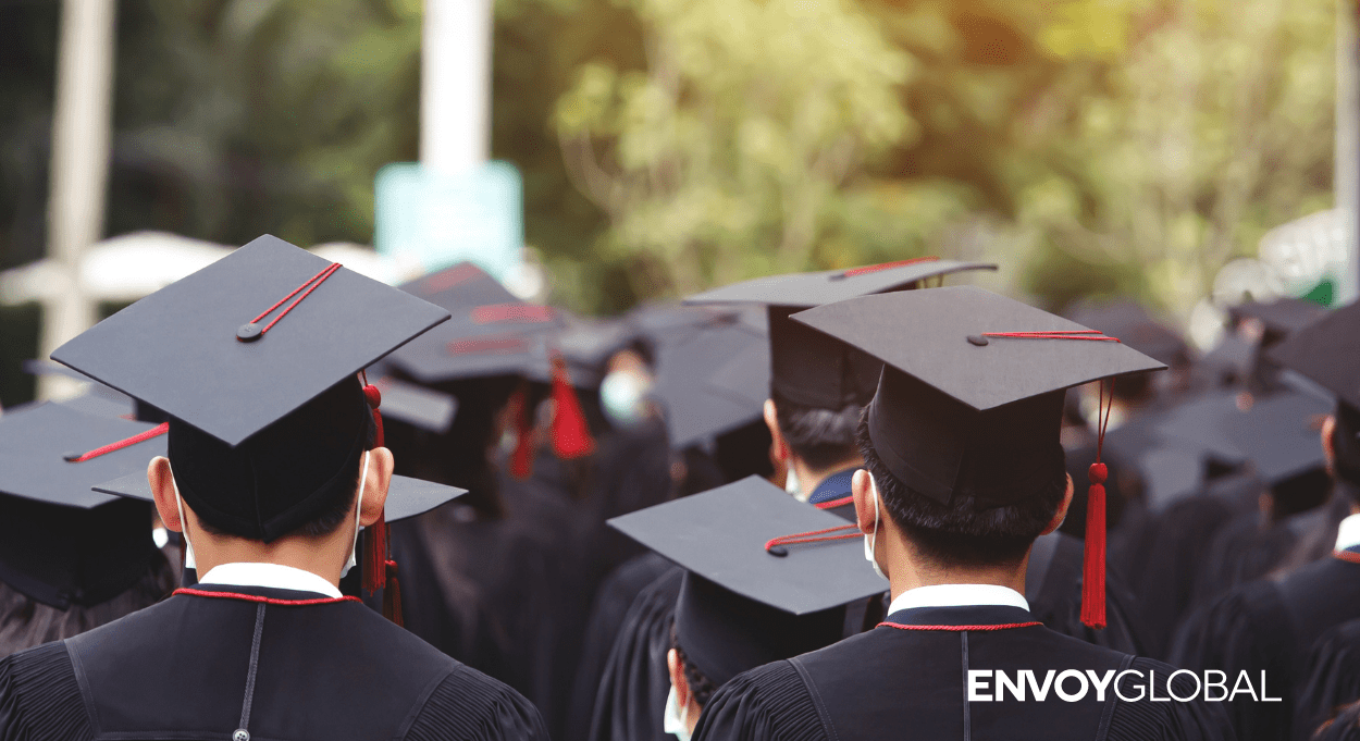 Image of students wearing graduation caps with the Envoy Global logo in the bottom right hand corner.