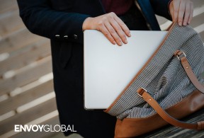 A person placing a laptop into her bag, illustrating the topic of electronic device searches by U.S. Customs and Border Protection.