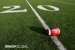 An American football lying on a playing field.